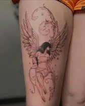 Fine line angel with wings and ornamental swirls on a thigh