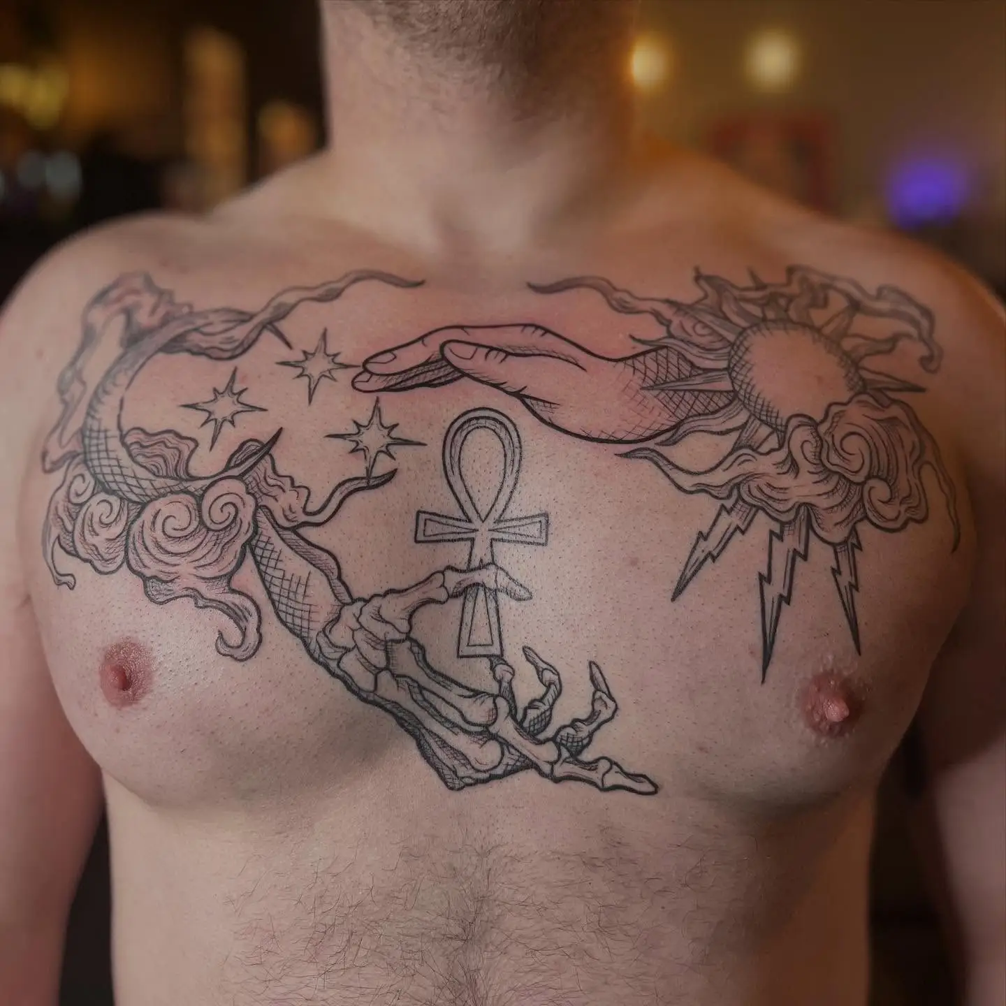 Woodcut style chest piece with a sun, moon and ankh