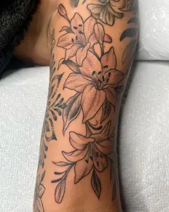 Black and grey lilies wrapping a forearm