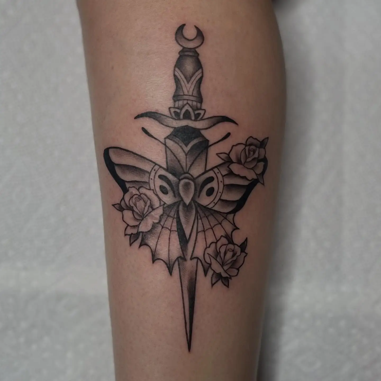 Traditional dagger through a moth with roses in black and grey