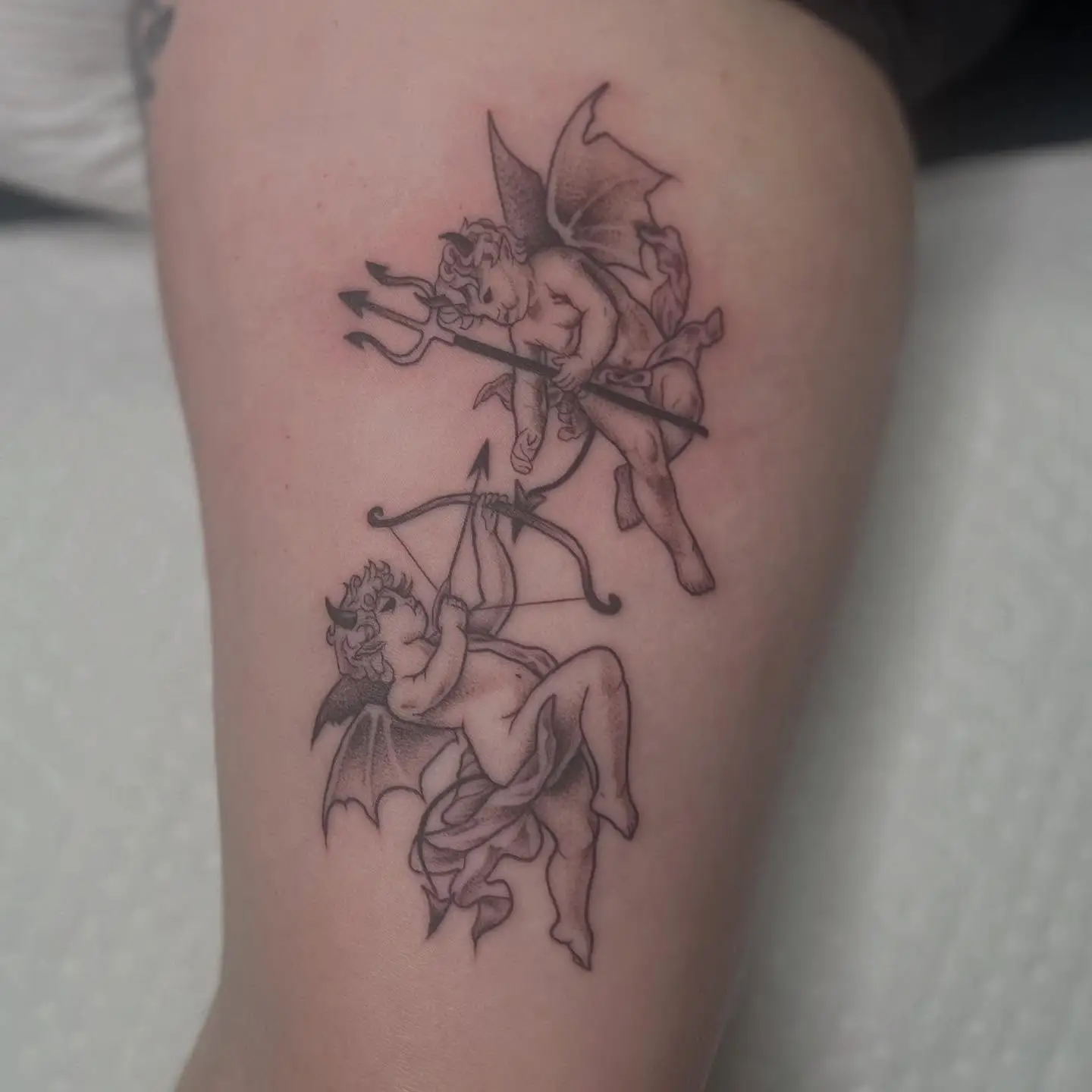 Two stipple shaded devil cherubs with small wings