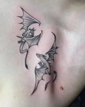 Two small black and grey dragons on a chest