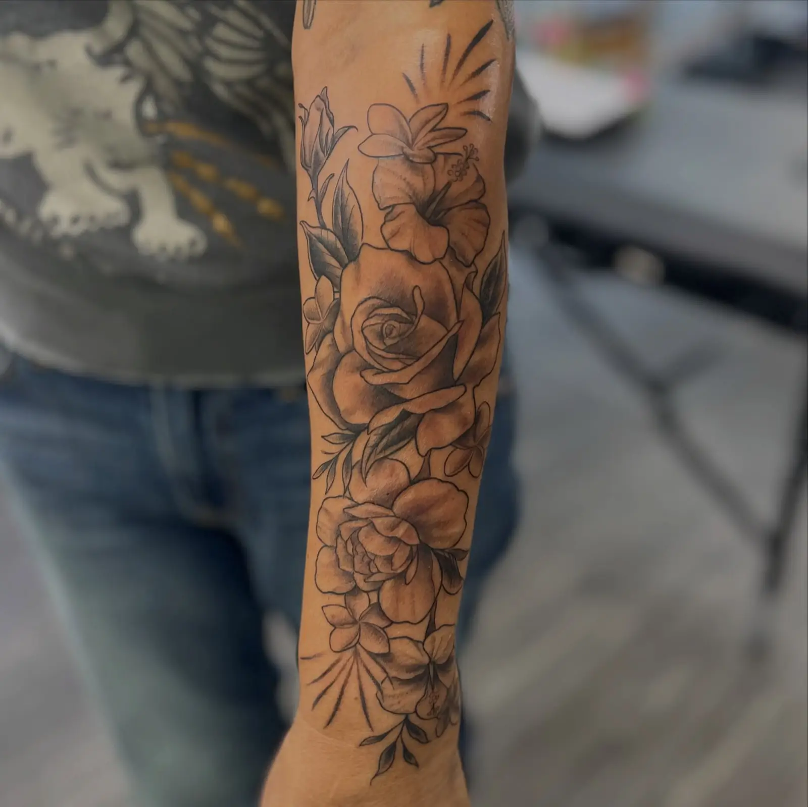 Black and grey floral half sleeve with roses on a forearm