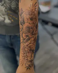 Black and grey floral half sleeve with roses on a forearm