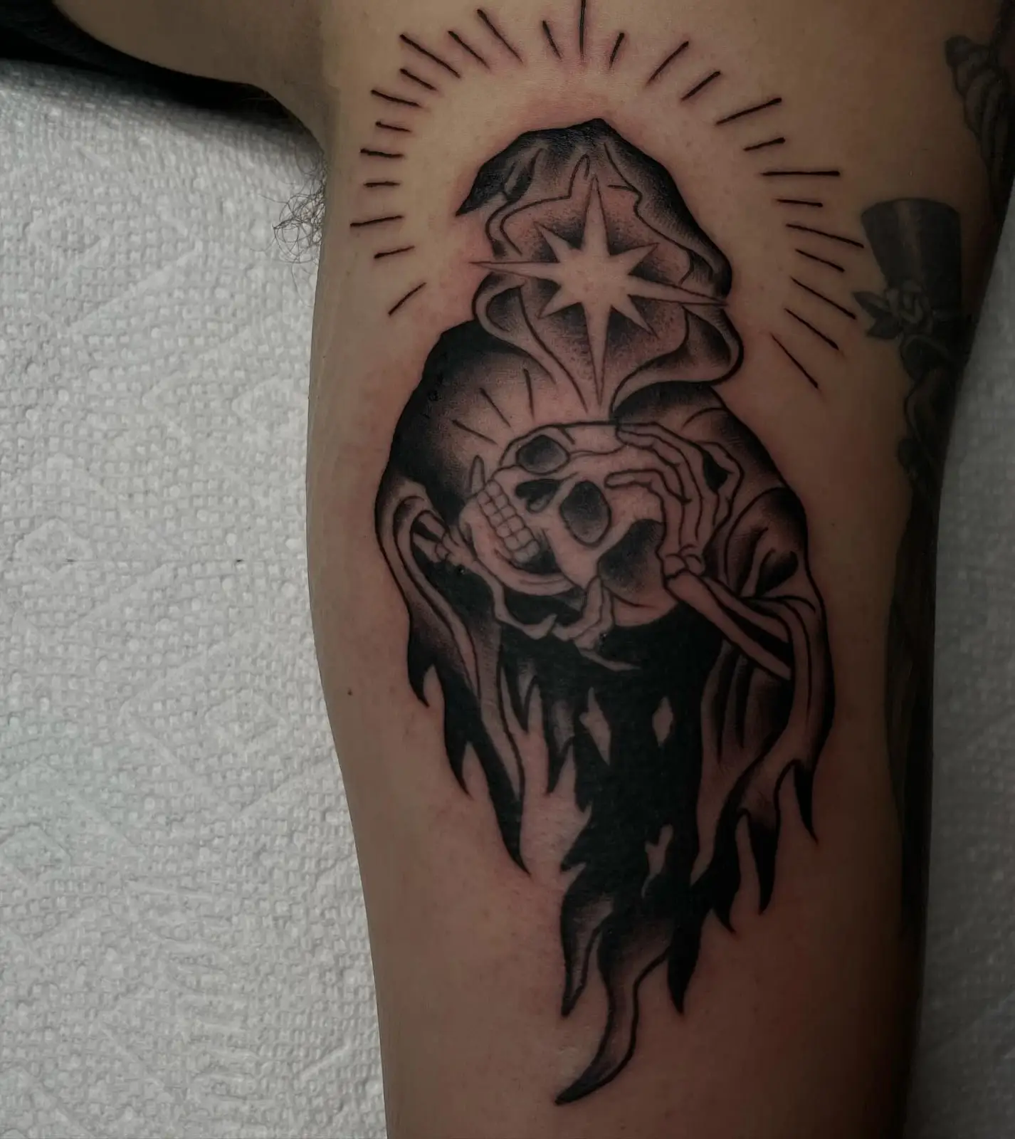 Traditional grim reaper with a halo in black and grey
