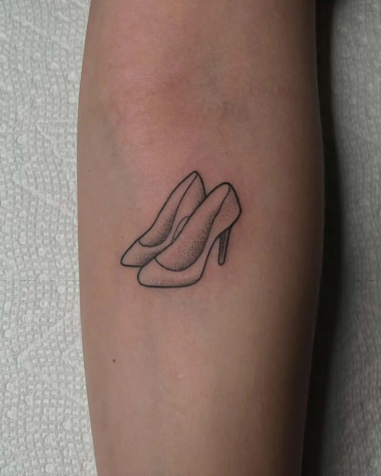 Fine line pair of heels on a forearm