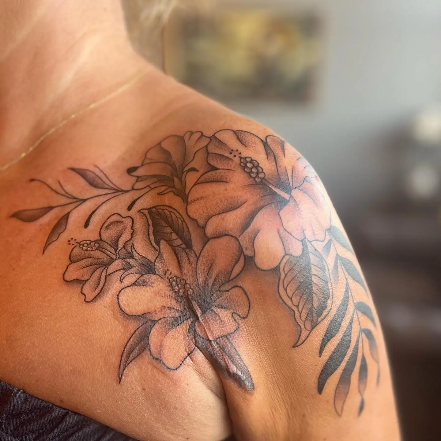 Hibiscus and lilies across a shoulder