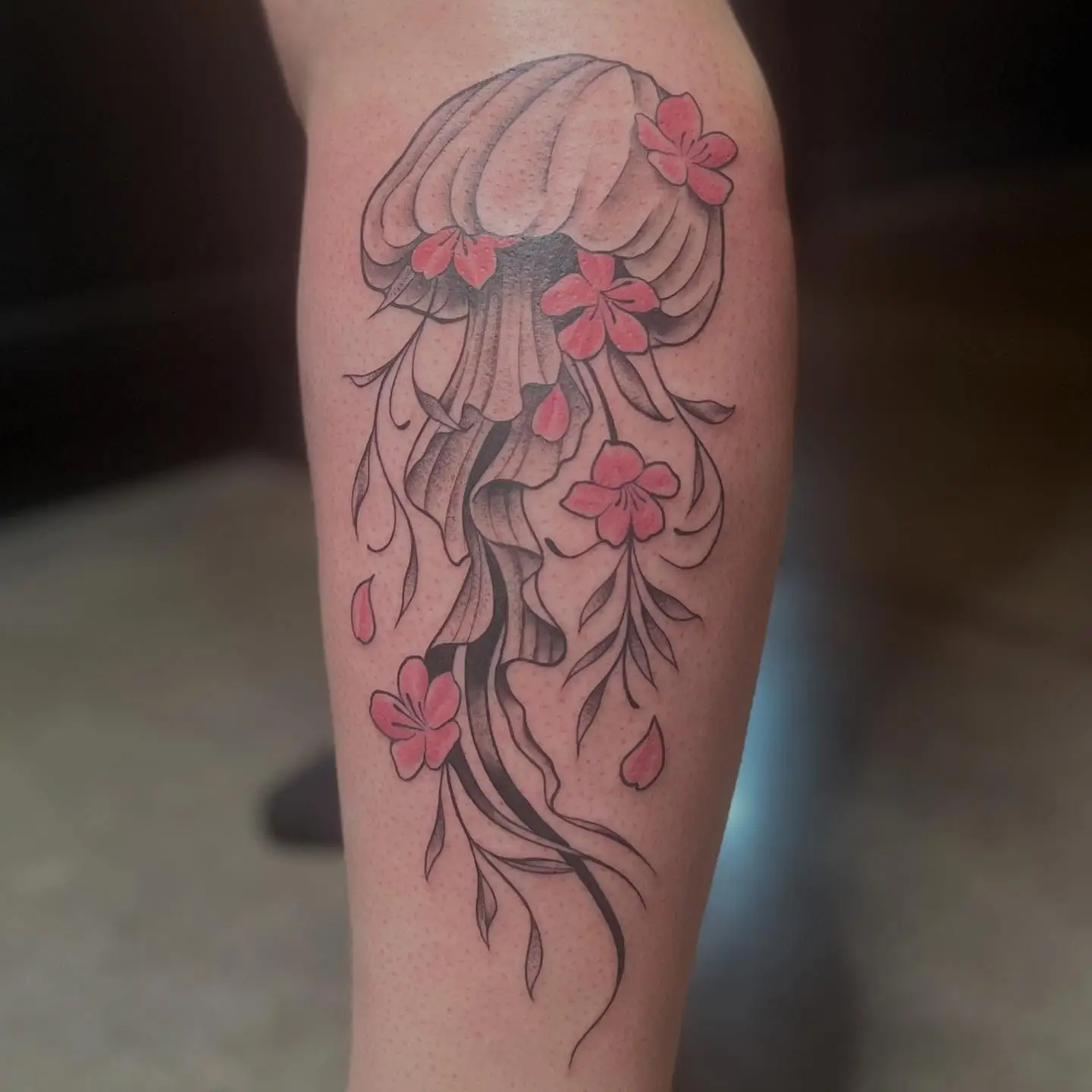 Jellyfish tattoo with pink cherry blossoms in its tentacles