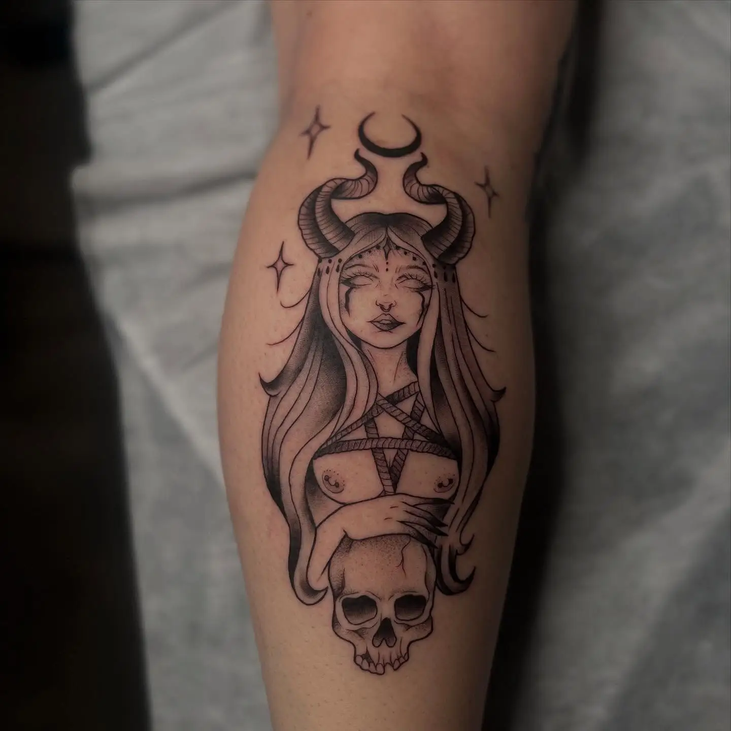 Horned woman with a skull in black and grey