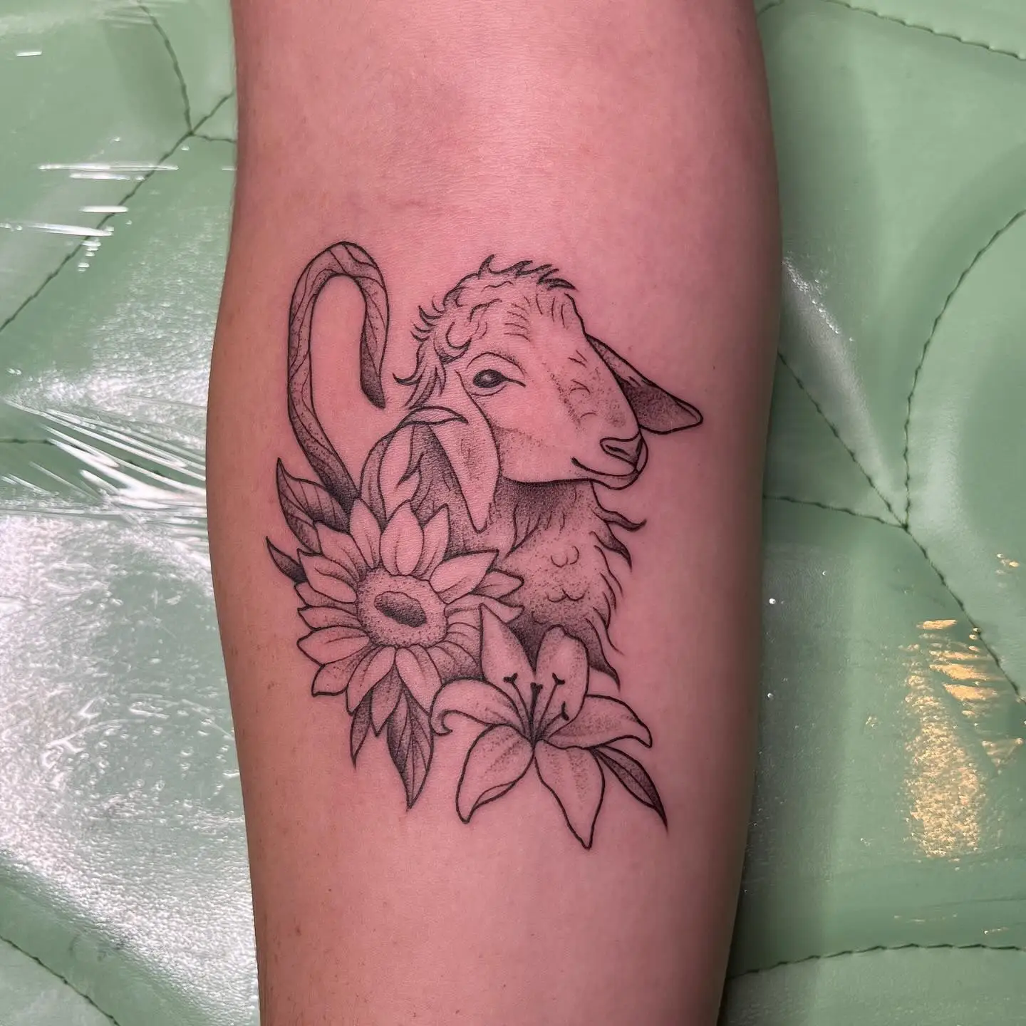 Fine line lamb with a sunflower and lily on a forearm