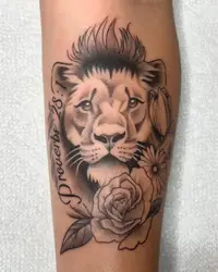 Black and grey lion portrait with a rose and script on a forearm