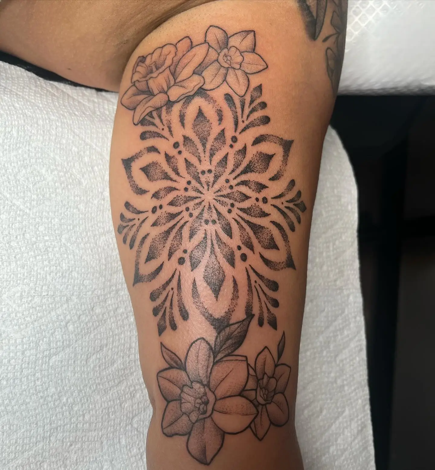Dotwork mandala with flowers on a forearm