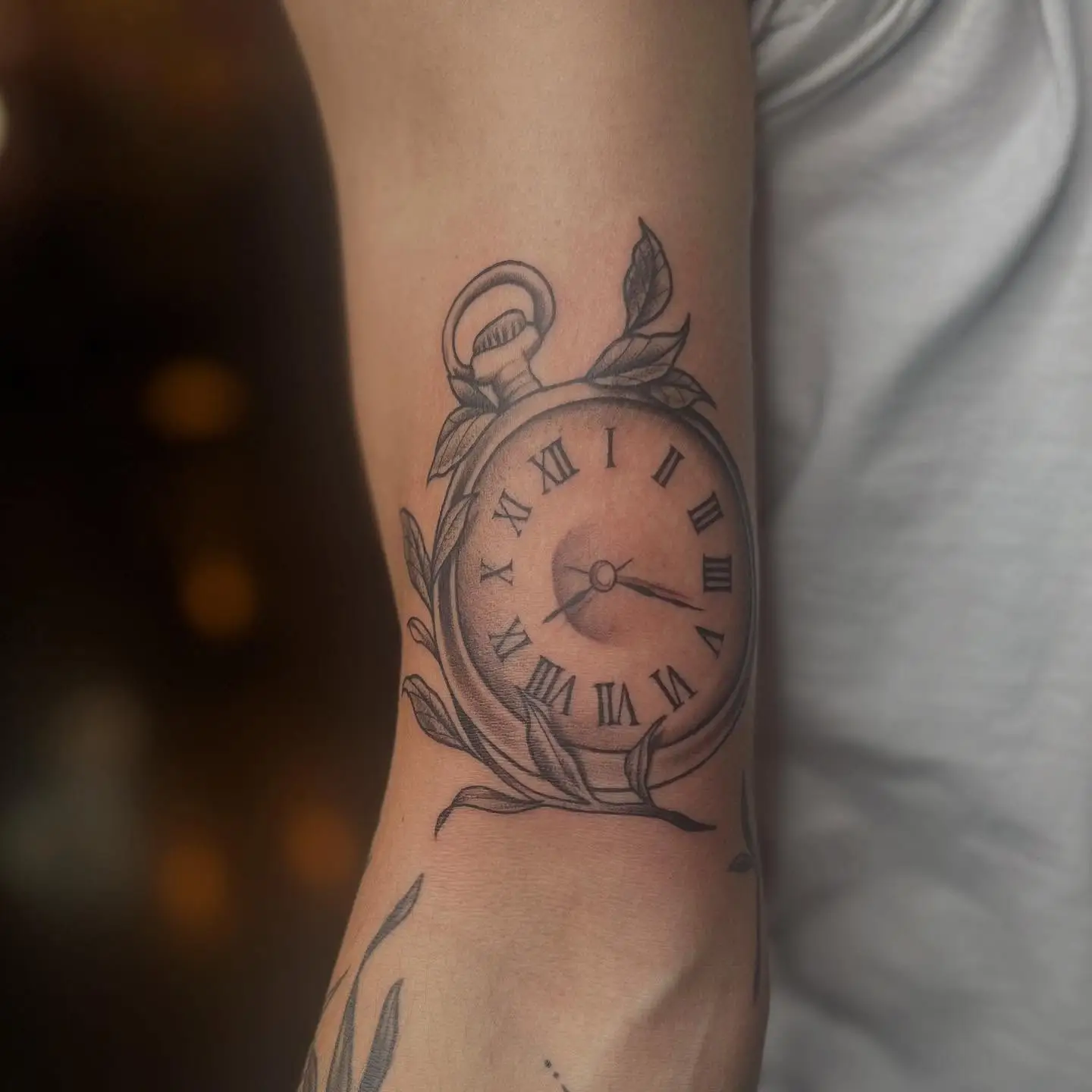 Black and grey pocket watch with leaves