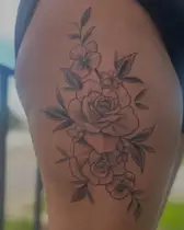 Stacked black and grey roses on the side of a thigh