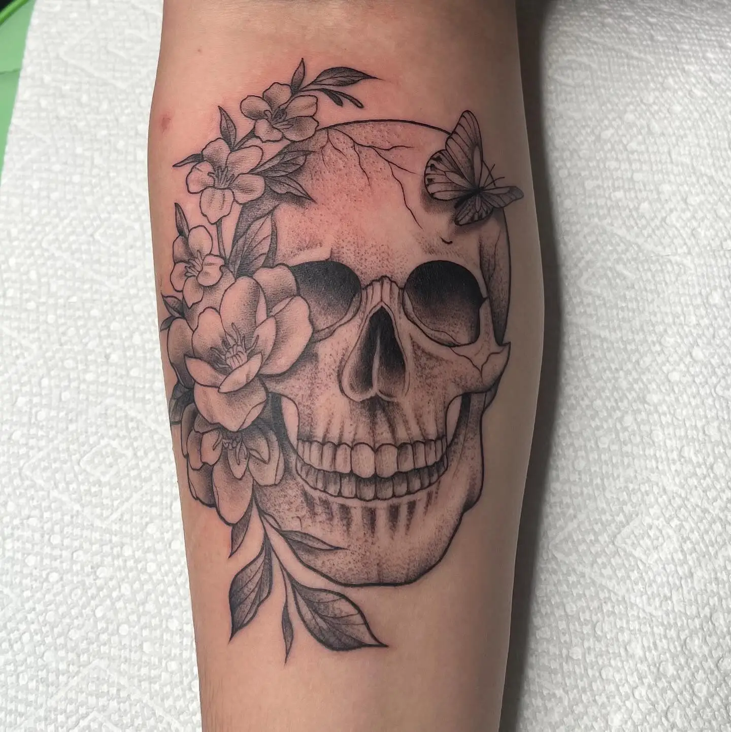 Black and grey skull with flowers and a butterfly