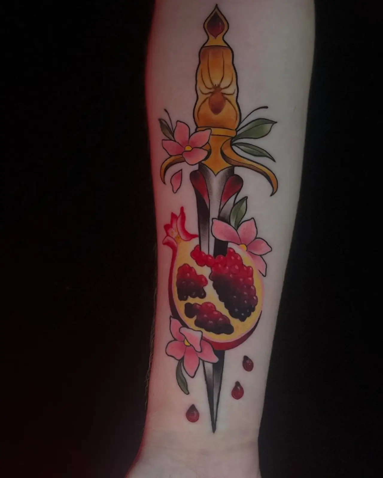 Dagger through a pomegranate with a spider in red and black