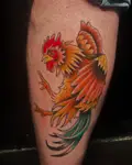 American traditional rooster tattoo in red, orange and green on a calf