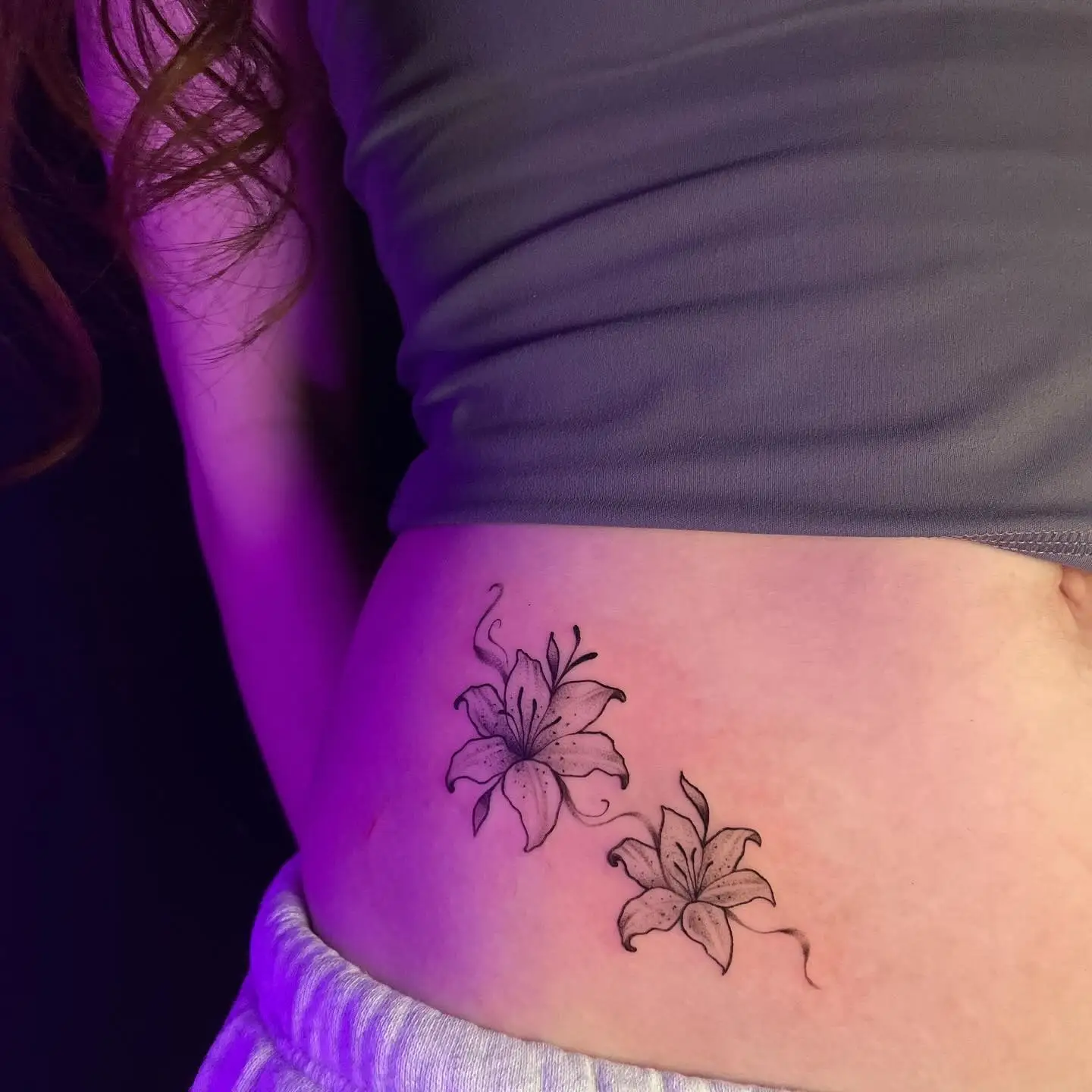 Two small fine line lilies on a hip