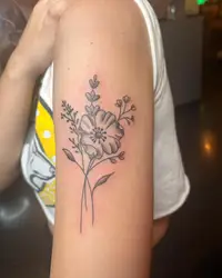 Fine line wildflower bouquet on an upper arm
